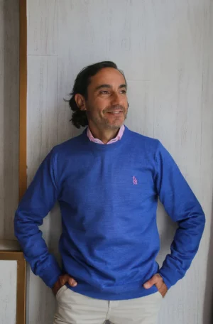 Jersey liso cuello caja azul con logo bordado en color rosa claro.